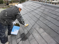 高圧洗浄の屋根にシーラーを塗装する職人